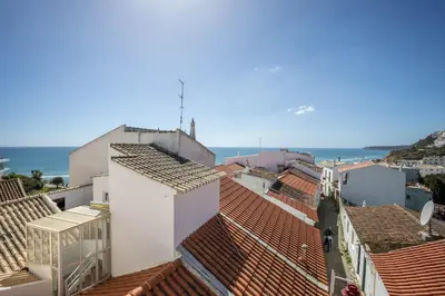 a view of roofs of buildings and the ocean at Casa Da Paz in Salema