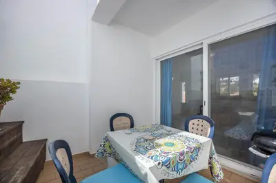 a dining room with a table and chairs and a window at Casa Da Paz in Salema