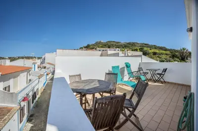 a balcony with chairs and a table on a roof at Casa Da Paz in Salema