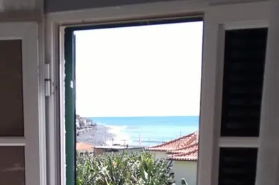 a sliding glass door with a view of the ocean at Casa MAR in Madalena do Mar