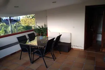 a dining room with a glass table and chairs at Casa MAR in Madalena do Mar