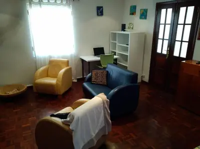 a living room with a couch and a chair and a desk at Casa MAR in Madalena do Mar