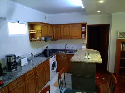 a kitchen with wooden cabinets and a counter top at Casa MAR in Madalena do Mar