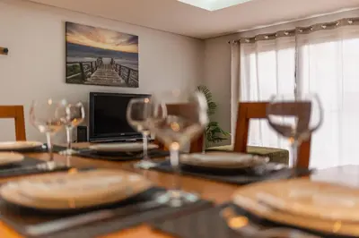 a dining room table with plates and wine glasses at Machico City Apt in Machico