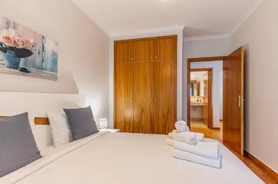 a bedroom with a large white bed with towels on it at Machico City Apt in Machico