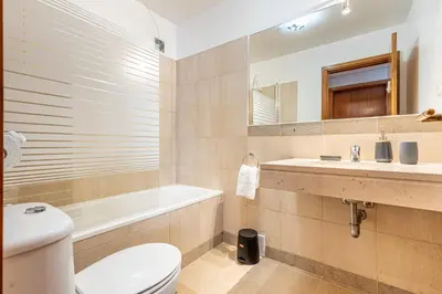 a bathroom with a toilet and a sink and a tub at Machico City Apt in Machico