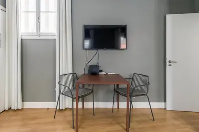 a table with two chairs and a television on a wall at Amazing Old Town - Apartments by SBH in Funchal