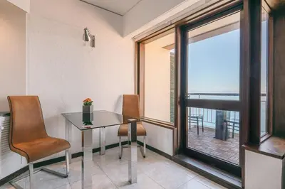 a dining room with a table and chairs and a window at Sunny Bayhill with swimming pool in Funchal