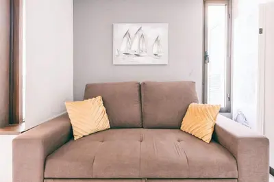 a couch in a living room with two pillows on it at Sunny Bayhill with swimming pool in Funchal
