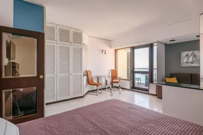 a bedroom with a bed and a table with chairs at Sunny Bayhill with swimming pool in Funchal