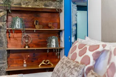 a bedroom with a wooden wall with shelves at King Shelter by Homie in Porto Moniz