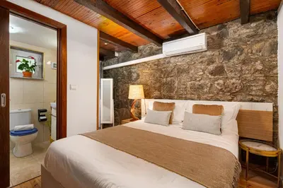 a bedroom with a large bed and a stone wall at King Shelter by Homie in Porto Moniz