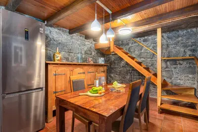 a kitchen with a wooden table and a stainless steel refrigerator at King Shelter by Homie in Porto Moniz