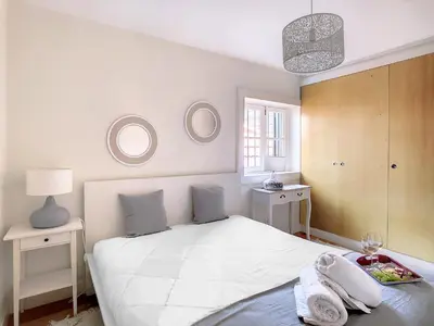 a bedroom with a large white bed with two mirrors at FX City Lover by LovelyStay in Funchal