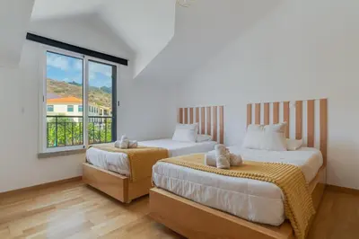 two beds in a room with a window at Desert Island Apartment by Atlantic Holiday in Caniço