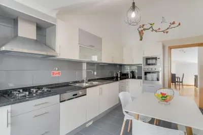 a kitchen with white cabinets and a white table at Desert Island Apartment by Atlantic Holiday in Caniço