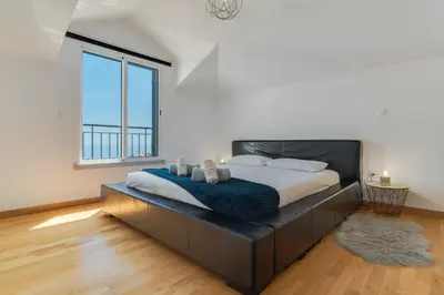a bedroom with a large bed with a large window at Desert Island Apartment by Atlantic Holiday in Caniço