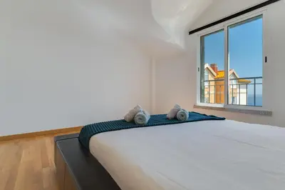 a bedroom with a large bed with a window at Desert Island Apartment by Atlantic Holiday in Caniço