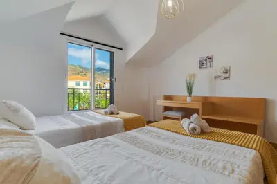two beds in a room with a window at Desert Island Apartment by Atlantic Holiday in Caniço