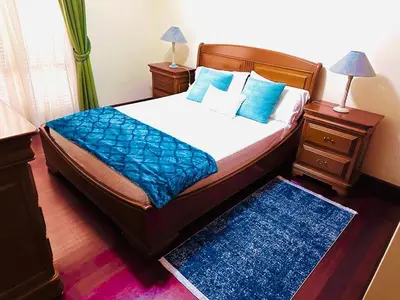 a bedroom with a bed with blue sheets and blue pillows at Smarts Apartment da Ajuda in Funchal