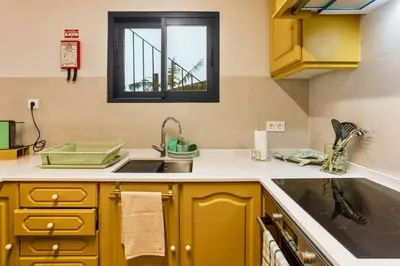 a kitchen with yellow cabinets and a sink and a window at Referta Apartamento T2 in Prazeres