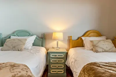 a bedroom with two beds and a lamp on a night stand at Referta Apartamento T2 in Prazeres