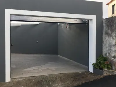 a garage with a black wall and a door at Referta Apartamento T2 in Prazeres