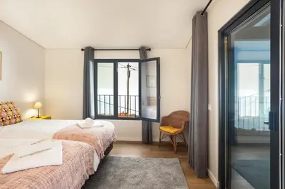 a bedroom with two beds and a sliding glass door at Referta Apartamento T1 in Prazeres