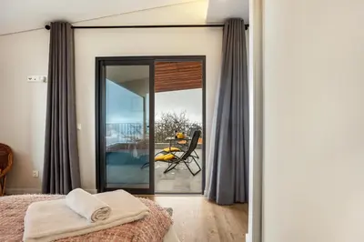 a bedroom with a glass door leading to a patio at Referta Apartamento T1 in Prazeres