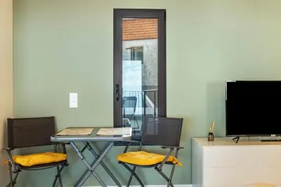 a table with two chairs and a television in a room at Referta Apartamento T1 in Prazeres