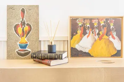 a shelf with books and a painting and a picture at Referta House in Prazeres