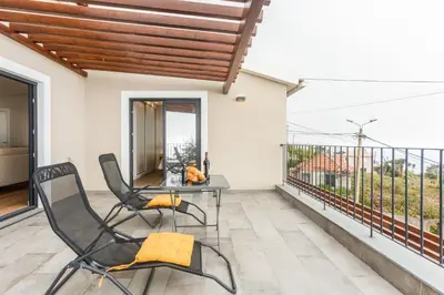 a balcony with two chairs and a table on a balcony at Referta House in Prazeres