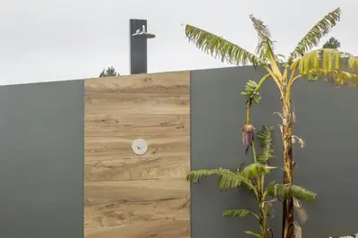 a wall with a wooden panel with a clock on it at Referta House in Prazeres