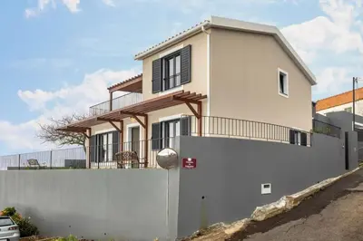a house with a white fence and a white wall at Referta House in Prazeres