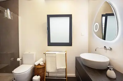 a bathroom with a sink and a toilet and a mirror at Referta House in Prazeres