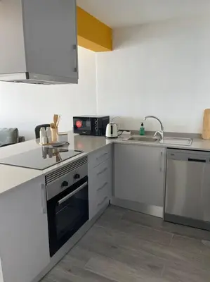 a white kitchen with a sink and a stove at top floor avenida arriaga 802 in Funchal