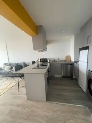 a kitchen with white counters and a stove top oven at top floor avenida arriaga 802 in Funchal