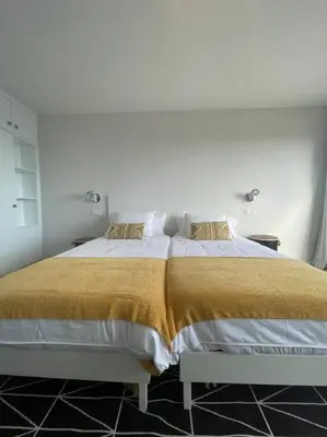 a white bedroom with a large bed with gold blanket at top floor avenida arriaga 802 in Funchal