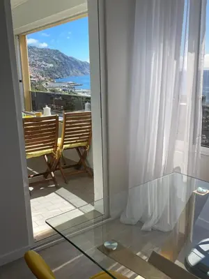 a room with a glass table and a balcony with a view at top floor avenida arriaga 802 in Funchal