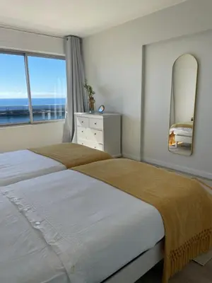 a bedroom with two beds and a large window at top floor avenida arriaga 802 in Funchal