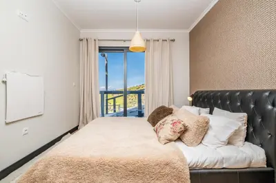 a bedroom with a bed with a large window at Ocean Panorama Apartments by Homie in Calheta