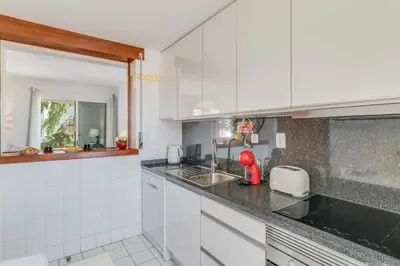 a white kitchen with a sink and a counter at Yellow Rose by AH in Funchal