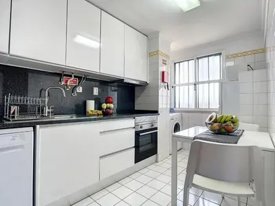 a kitchen with white cabinets and a bowl of fruit on a table at Yellow Rose by AH in Funchal