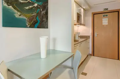 a white table in a kitchen with a vase on it at Dfm Happy Days E - Funchal in Funchal