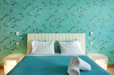 a bedroom with a blue bed with towels on it at Dfm Happy Days E - Funchal in Funchal