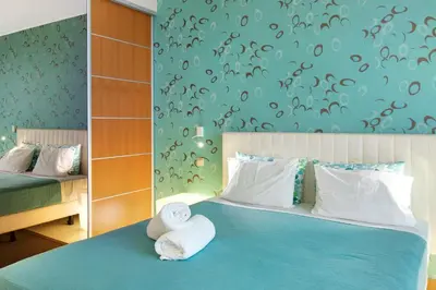 a bedroom with a blue bed with towels on it at Dfm Happy Days E - Funchal in Funchal