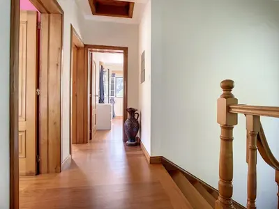 a hallway with white walls and wooden floors and a staircase at Mountain View Villa by Atlantic Holiday in São Vicente