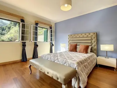 a bedroom with a bed and two windows at Mountain View Villa by Atlantic Holiday in São Vicente