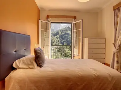 a bedroom with a bed and a large window at Mountain View Villa by Atlantic Holiday in São Vicente