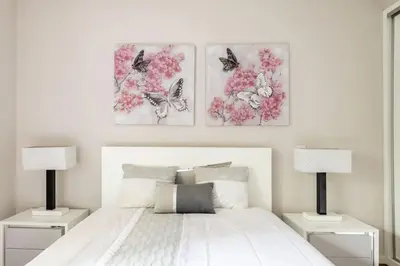a bedroom with two lamps and a bed with flowers at Luxury poolside view apartment in Funchal